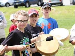 Ecole Franco-Nord students Brayden Boyle, left, Andrew Thurlow and Caleb Smith take part in a drumming workshop at a powwow at Ecole secondaire du Sacre-Coeur field in Sudbury, Ont. on Friday June 19, 2015. Hundreds of elementary school students from the four local school boards participated and watched traditional native dancing, took part in workshops that included drumming, playing Metis spoons, tipi teachings and trapping. The event was held to celebrate National Aboriginal Day which is on June 21. John Lappa/Sudbury Star/Postmedia Network