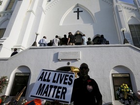 Church-goers wait to enter the Emanuel African Methodist Episcopal Church in Charleston, South Carolina June 21, 2015, for the first service in the church since a mass shooting left nine people dead during a bible study.    REUTERS/Brian Snyder