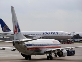 A United Airlines airplane passes by an American Airlines plane at the O'Hare Airport in Chicago, Illinois October 2, 2014. Incoming stormy weather and operational problems caused by a fire last week at a Chicago-area air traffic control facility forced the cancellation of nearly 750 flights on Thursday at Chicago airports.  REUTERS/Jim Young
