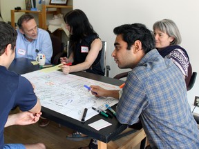 Stephen Leahy (left, back to camera) shares an idea with Himanshu Katyal (middle), and Susanne Cliff-Jungling (left) at a Sydenham St. Revived design and idea-sharing session  in Kingston, Ont. on Saturday June 20, 2015. Steph Crosier/Kingston Whig-Standard/Postmedia Network