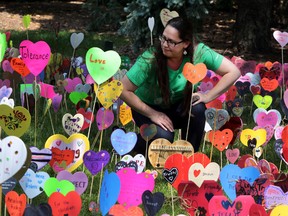 Miranda Jimmy takes a closer look at the Heart Garden at City Hall in Edmonton, Alberta on Sunday, June 21, 2015. Jimmy is the co founder of Rise (Reconciliation in Solidarity Edmonton), the group has put up 1100 hearts to raise awareness. Perry Mah/Edmonton Sun/Postmedia Network