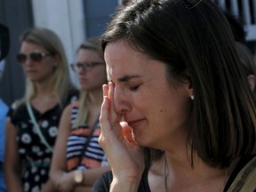 A church-goer who cannot fit into the Emanuel African Methodist Episcopal Church cries while standing in the street during a service in Charleston, South Carolina June 21, 2015. Hundreds of people flocked to Emanuel African Methodist Episcopal Church in Charleston on Sunday as it reopened its doors to worshipers just days after a gunman shot dead nine black church members.  REUTERS/Brian Snyder