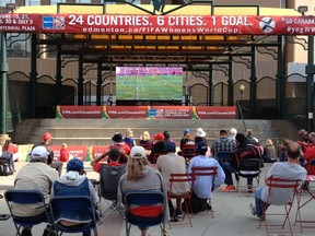 With Canadian flags in hand, soccer fans pulled up a seat to a big screen television outside the Stanley A. Milner Library Sunday night to watch Canada take on Switzerland in the FIFA Women’s World Cup. Photo by Pamela Roth