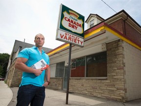 Michael Arntfield holds a copy of his new book, Murder City, outside the former Stanley Variety store in London, the last place teenage clerk Jacqueline Dunleavy was seen alive before her strangled, partly clothed body was found in January 1968. Her death remains one of many unsolved cases in a rash of killings decades ago that Arntfield argues made London the nation?s serial-murder capital. (CRAIG GLOVER, The London Free Press)