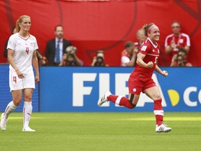 Rachel Rinast #4 of Switzerland looks on dejected as Josee Belanger #9 of Canada celebrates her goal during the FIFA Women's World Cup Canada 2015 Round 16 match between Switzerland and Canada June 21, 2015 at BC Place Stadium in Vancouver, British Columbia, Canada. (Jeff Vinnick/Getty Images/AFP)