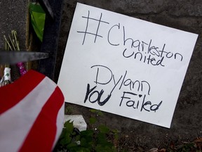 People is placed outside the Emanuel African Methodist Episcopal Church in Charleston, June 21, 2015. The church reopened on Sunday for its first service since nine people at a Bible-study meeting were shot dead on Wednesday by suspect Dylann Roof, a 21-year-old white man with a criminal record.      REUTERS/Carlo Allegri