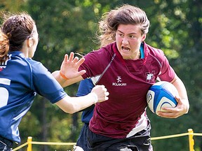 Belleville's Cindy Nelles fends off a U of T defender during OUA women's rugby action last season. (McMaster Athletics)
