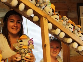 SAMANTHA REED/FOR THE INTELLIGENCER
Katlyn Anderson (left) and Jordan Davis (right) sit on the staircase at the Belleville and District Chamber of Commerce Log Cabin surrounded by PACHI dolls. PACHI is the official mascot for the Pan Am and Parapan Am Games. The city will be hosting a celebration for the games July 3.