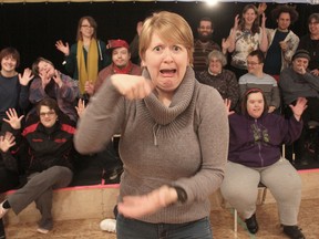As students from the H'art Centre in Kingston, Ont. give the American Sign Language sign for "applause" behind her, deaf actor Elizabeth Morris demonstrates the use of facial and body language. She will be one of three artists holding a workshop in ASL on Sunday. (Michael Lea/The Whig-Standard)