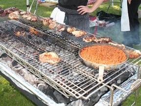 Chef Kelly Hamilton, who teaches the culinary program at John Paul II Catholic secondary school, works the grill at last year’s Feastival. The London Training Centre is hosting the annual fundraiser this year on July 9, 2015. (Photo courtesy of London Training Centre)