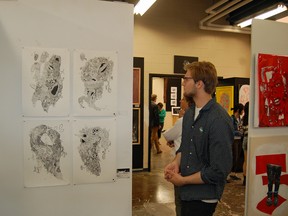 bealart student Elliott Moore checks out some of the art on display at bealart's annual Year End Show and Sale Showcase, held on June 13.