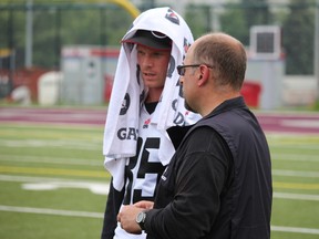 Matt Carter, talking to Ottawa RedBlacks GM Marcel Desjardins, is on the six-game injured list. He says he hasn't gotten any better since being whacked in the chin two weeks ago in Hamilton. (TIM BAINES/OTTAWA SUN)