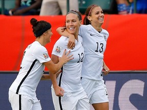 Alex Morgan (13) of the United States celebrates with teammates Lauren Holiday (12) and Alex Krieger (11) after Morgan scores her first goal against Colombia in the second half in the FIFA Women's World Cup 2015 Round of 16 match at Commonwealth Stadium on June 22, 2015 in Edmonton, Canada.  (AFP)