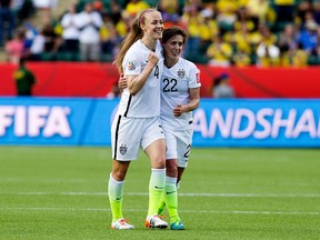United States' Becky Sauerbrunn (4) and Meghan Klingenberg (22) celebrate a 2-0 win over Colombia during second half FIFA Women's World Cup Canada 2015 action at Commonwealth Stadium, in Edmonton Alta. on Monday June 22, 2015. David Bloom/Edmonton Sun/Postmedia Network