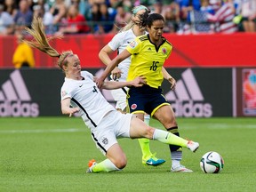 United States’ Becky Sauerbrunn, No. 4, tackles Colombia’s Lady Andrade, No. 16, during second-half action Monday. (David Bloom, Edmonton Sun)