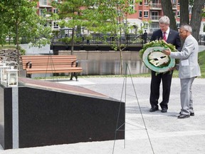 Prime Minister Stephen Harper, left, and Dr. Bal Gupta, who lost his wife in the 1985 Air India bombing, lay a wreath during the unveiling ceremony of the Air India Memorial in Montreal, Que., on June 23, 2011. (REUTERS/Christinne Muschi)