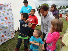 Cochrane played host as resident members of the First Nations celebrated Aboriginal Days, June 21. Here, Traven Archibald, two and the shortest of the participants, enthusiastically tries his hand at the fish pond while others wait their turn.