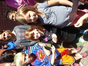 Rayna Begin-Onolack a student of Cochrane Public School holds one of the butterflies that the two classes released. She is surrounded by Natalya Cheechoo, Abby Sutherland, Tia Iserhoff, Madison Nakogee and Addison James and other members of the school.