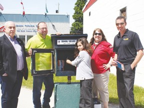 Filling up the first of 11 Book Share Boxes are David Butler, Financial Controller and Business Manger for CGV, Shane Skinner, Director of Operations and Infrastructure, Aaron Lavoie, and Mary-Ann Parsley of the Cochrane Cubs and J.P. Ouellette, CAO of the Town of Cochrane.