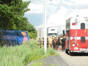 Emergency response crews on scene to assist injured passengers that were brought out of a Megabus that collided into trees on the northside of the westbound lanes  of Hwy. 401 after striking a tractor-trailer about two kilometres east of Lancaster, Ont.on Tuesday June 23, 2015. Greg Peerenboom/Cornwall Standard-Freeholder/Postmedia Network