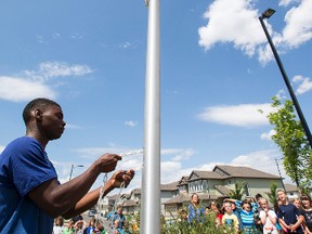 The Canadian flag is raised during a ribbon cutting and memory box presentation ceremony held in Edmonton Police Service Cst. Daniel Woodall's memory at Monsignor Fee Otterson School in Edmonton, Alta., on Tuesday June 23, 2015. Woodall was killed in the line of duty on June 8, 2015. Ian Kucerak/Edmonton Sun/Postmedia Network