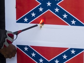 Protesters burn paper Confederate flags during a rally on June 23, 2015 in Los Angeles, California. Ringo Chiu/Getty Images/AFP