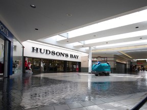 A worker cleans up water after heavy overnight rain left parts of White Oaks Mall flooded Tuesday. While portions of the mall opened on time, some stores that received heavier flooding remained closed into the afternoon. (CRAIG GLOVER, The London Free Press)