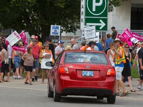 Striking CUPE Local 101 workers stop a car trying to enter the underground parking lot beneath City Hall in London. The strike captain at right, equipped with a stopwatch, said the picketers were delaying people for about 8-10 minutes. (MIKE HENSEN, The London Free Press)