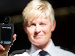Deputy Chief Danielle Campbell holds up a body worn camera during an Edmonton Police Service news conference at EPS Headquarters in Edmonton, Alta., on Tuesday June 23, 2015. Police released the results of a three year study to assess the effectiveness of body worn video at the conference. Ian Kucerak/Edmonton Sun/Postmedia Network