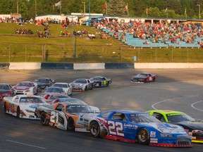 The Late Model heat runs through the shadows as the crowd on the hill basks in the last of the day's sunlight at Delaware Speedway in this Free Press file photo.