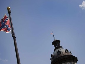 The Confederate Flag flies on the South Carolina State House grounds in Columbia, South Carolina, June 24, 2015.  The Confederate battle flag was taken down Wednesday outside Alabama's state legislature as Americans increasingly shun the Civil War era saltire after the Charleston church massacre. AFP/JIM WATSON