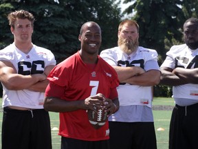 Ottawa RedBlacks starting QB Henry Burris (second from left) poses with linemen (from far left) Nolan MacMillan,Jon Gott and J'Michael Dean after a morning walkthrough at Keith Harris Stadium, Wednesday, June 24, 2015. Burris, Walker and the RedBlacks later bused to Montreal where the team will open their second CFL season versus the Alouettes on Thursday night. Mike Carroccetto / Ottawa Sun
