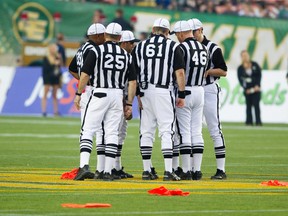 Referees huddle up amongst multiple flags as they decide what to do after a heated tussle between the Edmonton Eskimos and the Winnipeg Blue Bombers during second half CFL action at Commonwealth Stadium in Edmonton, Alberta on Friday, July 13, 2012.   (AMBER BRACKEN/EDMONTON SUN)