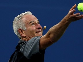 John McEnroe serves during an exhibition doubles match during the 2014 U.S. Open at the USTA Billie Jean King National Tennis Center on September 3, 2014 in New York City. (Elsa/Getty Images/AFP)