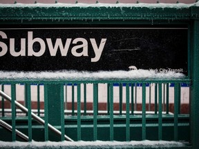 A snow covered subway sign is seen in New York's Times Square February 2, 2015. A huge winter storm hit the northeastern United States on Monday, the region's second snowy blast in less than a week, after leaving more than a foot (30 cm) of snow in the Chicago area. Up to six inches (15 cm) of snow was forecast for New York City, where the snow and ice caused a crowded subway train to stall on an elevated stretch of track.  REUTERS/Brendan McDermid