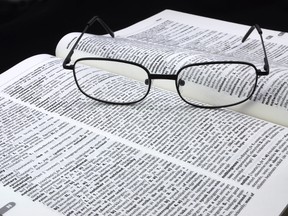Glasses resting on a dictionary. (Fotolia)