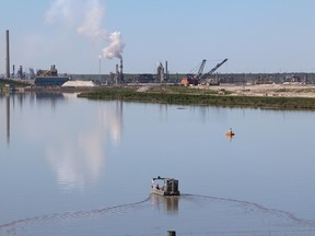 Syncrude workers in a recovery boat patrol a tailings pond north of Fort McMurray Alta. on Friday June 19, 2015. Vincent McDermott/Fort McMurray Today/Postmedia Network
