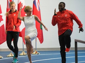 Premier Kathleen Wynne works on her tempo with Canadian Pan Am track and field athletes, Jenna Martin-Evans, left,  and Sam Effah at the YMCA in the Athletes Village on June 25, 2015. (Craig Robertson/Toronto Sun)