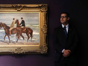 A security guard stands near "Zwei Reiter am Strand mach links (Two Riders on a Beach)" by Max Liebermann at Sotheby's in London, Britain June 19, 2015. The painting was successfully restituted to it's original owner after being seized by the Nazi's in the 1930's, but in the U.S. museums are evading similar restitution. REUTERS/Suzanne Plunkett