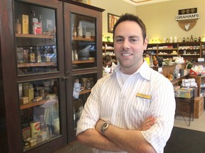 David Graham, owner of Graham's Pharmacy in downtown Kingston, Ont., stands in front of one of the display cases housing artifacts from his apothecary museum on Thurs., June 25, 2015. The museum includes old patent medicines, elixirs, liniments and medications. Michael Lea/The Whig-Standard/Postmedia Network