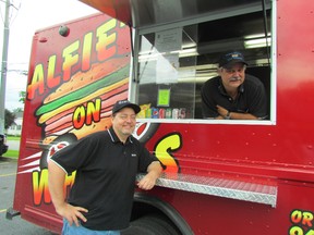 Tony Haines, owners of Alfie's Deli, leans through the window of Alfie's on Wheels, his new sandwich truck. With him is his cousin Farron Adams, who works for the business, Thursday June 25, 2015 in Sarnia, Ont. Paul Morden/Sarnia Observer/Postmedia Network