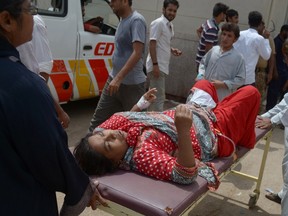 Pakistani relatives bring a heatstroke victim to a hospital in Karachi on June 25, 2015. The death toll from a major heatwave in Pakistan passed 1,000 on June 25, 2015, medics and welfare workers told AFP, with further fatalities expected. AFP PHOTO / RIZWAN TABASSUM