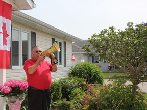 Dick Hagle, 72, stands armed with a megaphone at his home in Bluewater Country. He's hoping to drum up support for the community's fourth annual Canada Day parade.
Photo taken Friday, June 26, 2015 near Sarnia, Ontario. CHRIS O’GORMAN/ SARNIA OBSERVER/ POSTMEDIA NETWORK