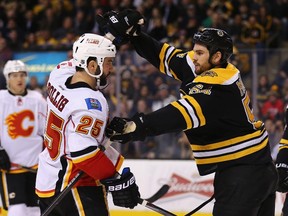 Adam McQuaid (right) of the Boston Bruins and Brandon Bollig of the Calgary Flames shove each other during NHL action at TD Garden on March 5, 2015 in Boston. (Maddie Meyer/Getty Images/AFP)