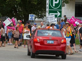 Striking CUPE Local 101 workers are shown stopping cars attempting to enter the underground parking lot beneath city hall earlier this week. (MIKE HENSEN, London Free Press)