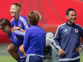 Japanese players and their coach Norio Sasaki share a laugh during practice on Friday. (AFP)
