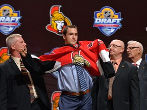 Colin White puts on a team jersey after being selected as the number 21 overall pick to the Ottawa Senators in the first round of the 2015 NHL Draft at BB&T Center. Steve Mitchell/USA Today