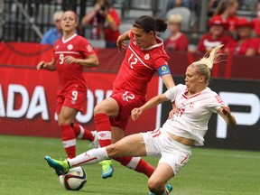 Canada's Christine Sinclair, left, and Switzerland's Lara Dickenmann battle for the ball last Sunday in Vancouver during the FIFA Women's World Cup. (Carmine Marinelli/Postmedia Network)