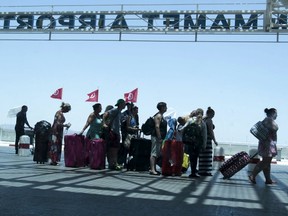 Tourists queue to leave Tunisia at the Enfidha international airport, June 27, 2015. British tourist companies were evacuating thousands of foreign holidaymakers from Tunisia on Saturday, a day after a gunman killed 39 people as they lounged at the beach in an attack claimed by Islamic State. Picture taken through a window. REUTERS/Zoubeir Souissi