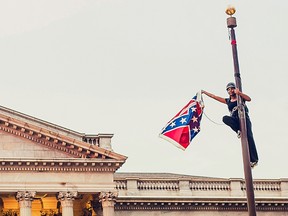 Bree Newsome takes down the Confederate Flag from a pole at the Statehouse in Columbia, S.C., June 27, 2015. (Reuters/Adam Anderson Photo)